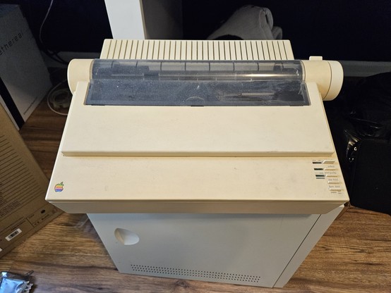 an Apple ImageWritter II dot-matrix printer sits on top of an old PC